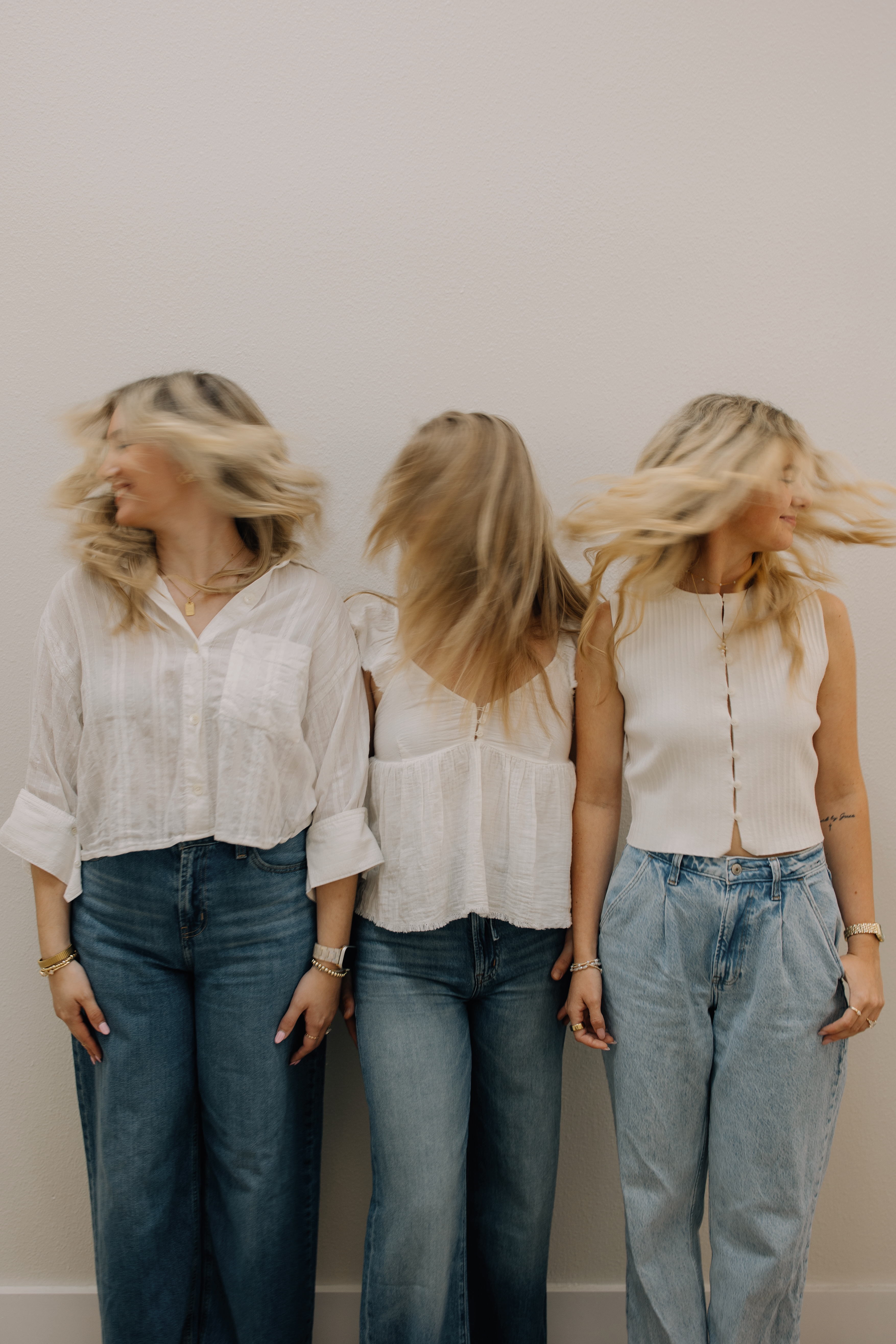 Three Riah Salon team members sharing a playful hair flip